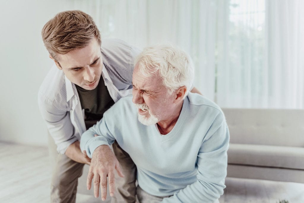 young man helps grandfather after stroke