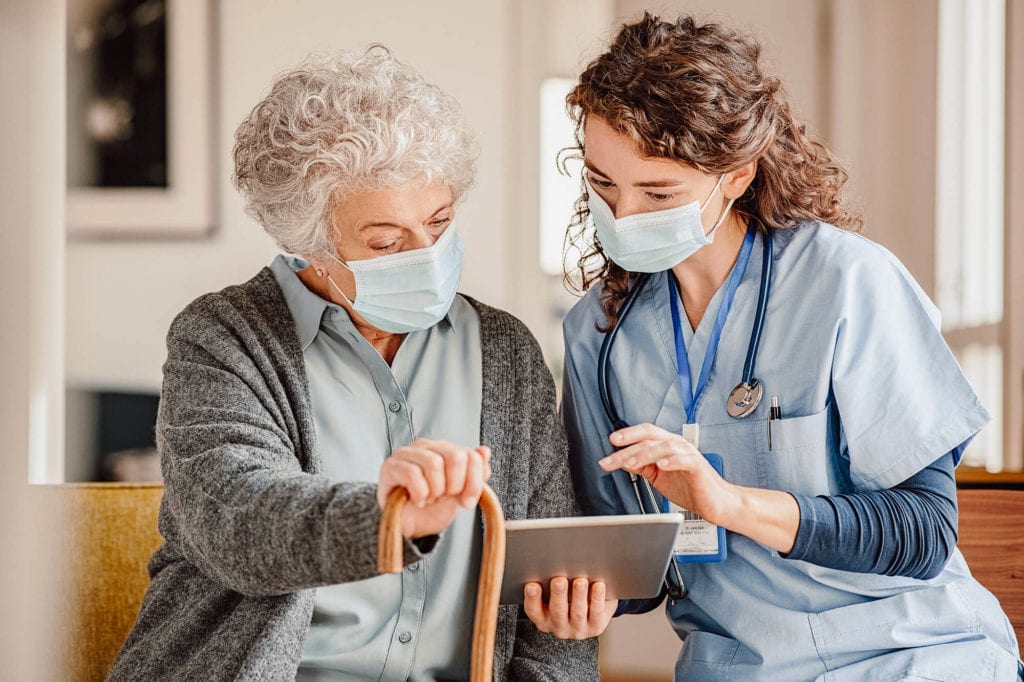 caregiver helps female patient by explaining the rehabilitation scheme